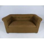 Small antique upholstered two seater sofa on castors