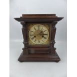 Architectural style mantle clock with brass face and Roman numeral chapter ring