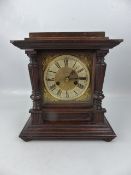 Architectural style mantle clock with brass face and Roman numeral chapter ring