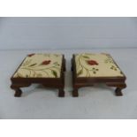 Two footstools with carved frame, upholstered with new floral upholstery