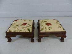 Two footstools with carved frame, upholstered with new floral upholstery