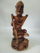 Chinese style carved wooden figure of an elder. Signed to base