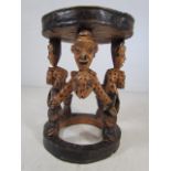 Carved African stool the legs highly carved as animals and people