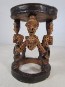 Carved African stool the legs highly carved as animals and people