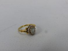 18ct Gold ladies ring set with pale blue stone (rubbed) surrounded by small diamond chips