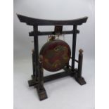 Chinese gong on wooden ebonised stand, the gong with painted dragon