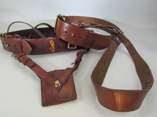 Two Sam Browne belts, one with sword holster and etched with name of ...