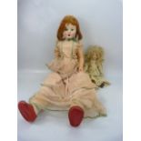 Two porcelain-headed dolls, one approx. 84cm tall, the other approx 38cm tall