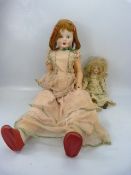 Two porcelain-headed dolls, one approx. 84cm tall, the other approx 38cm tall