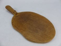 A Robert Mouseman Thompson of Kilburn carved oak cheese/ bread board, oval form with carved mouse to