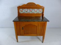 Wash stand with marble top and rose patterned tiled splash back