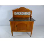 Wash stand with marble top and rose patterned tiled splash back