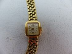 A Lady's 18ct Bucherer Wrist Watch. The watch having a silvered face with baton dial, benefiting