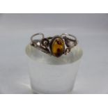Silver bangle set with central amber surrounded by floral design