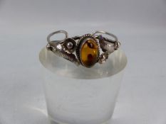 Silver bangle set with central amber surrounded by floral design