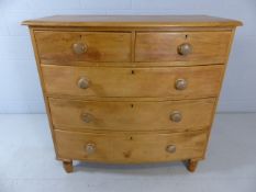 Bow fronted pine chest of drawers on turned feet with three large drawers and two over