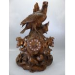 Large Black Forest heavily carved clock decorated with birds, with central clock face with enamel