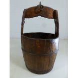 Rustic bound wooden water bucket with handle and iron loop