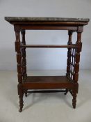 Marble topped three tier table with fretwork to sides and ceramic castors