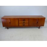 Mid century sideboard with two cupboards with retractable doors and three central drawers. Marked