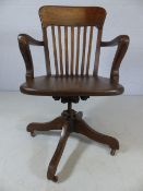Oak slat-backed captain's chair on castors