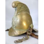 An early 20th century brass fireman's helmet. High comb design with dragon decoration and crossed