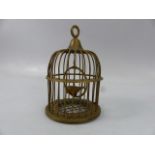 Brass bird in a cage on swinging hoop