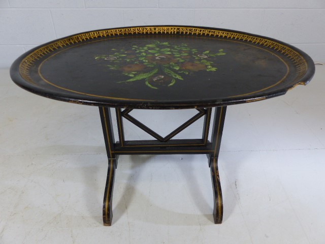 Ebonised Tilt top oval table decorated with flora and forna