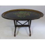 Ebonised Tilt top oval table decorated with flora and forna
