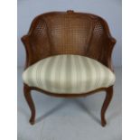 Wicker backed modern bedroom chair upholstered in green and cream fabric