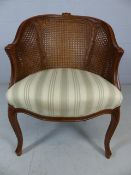 Wicker backed modern bedroom chair upholstered in green and cream fabric