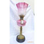 Victorian oil lamp with brass corinthian column on circular ebonised plinth,