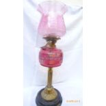 Victorian oil lamp with brass corinthian column on circular ebonised plinth,