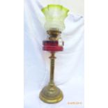 Brass circular based Victorian oil lamp with dark cranberry glass bowl and etched part green glass