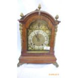 Decorative oak hooded cased German mantel clock with gilded and steel dial with roman numerals,