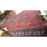 Crimson ground Indian carpet with three multi coloured diamonds to the central field (approx 108" x