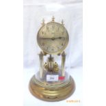 Schatz steel and brass dialed mantel clock on circular base within glass domed case