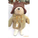 Paddington Bear dressed in dark brown bonnet and duffel coat