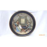 Musterschutz oval wall plaque with raised decoration of a couple of Minstrels seated beside a table