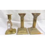 Pair of corinthian column brass candlesticks and another