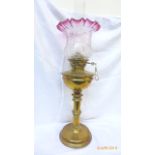 Brass oil lamp with decorative cranberry and clear glass shade