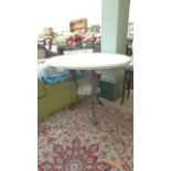 White painted circular topped garden/occasional table on ornate three shaped iron feet with