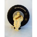 A seated Michelin Mr. Bibendum sat in a tyre display.