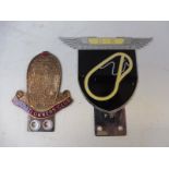 A reproduction Brooklands enamel car badge depicting the circuit and a Bugatti Owners Club badge.