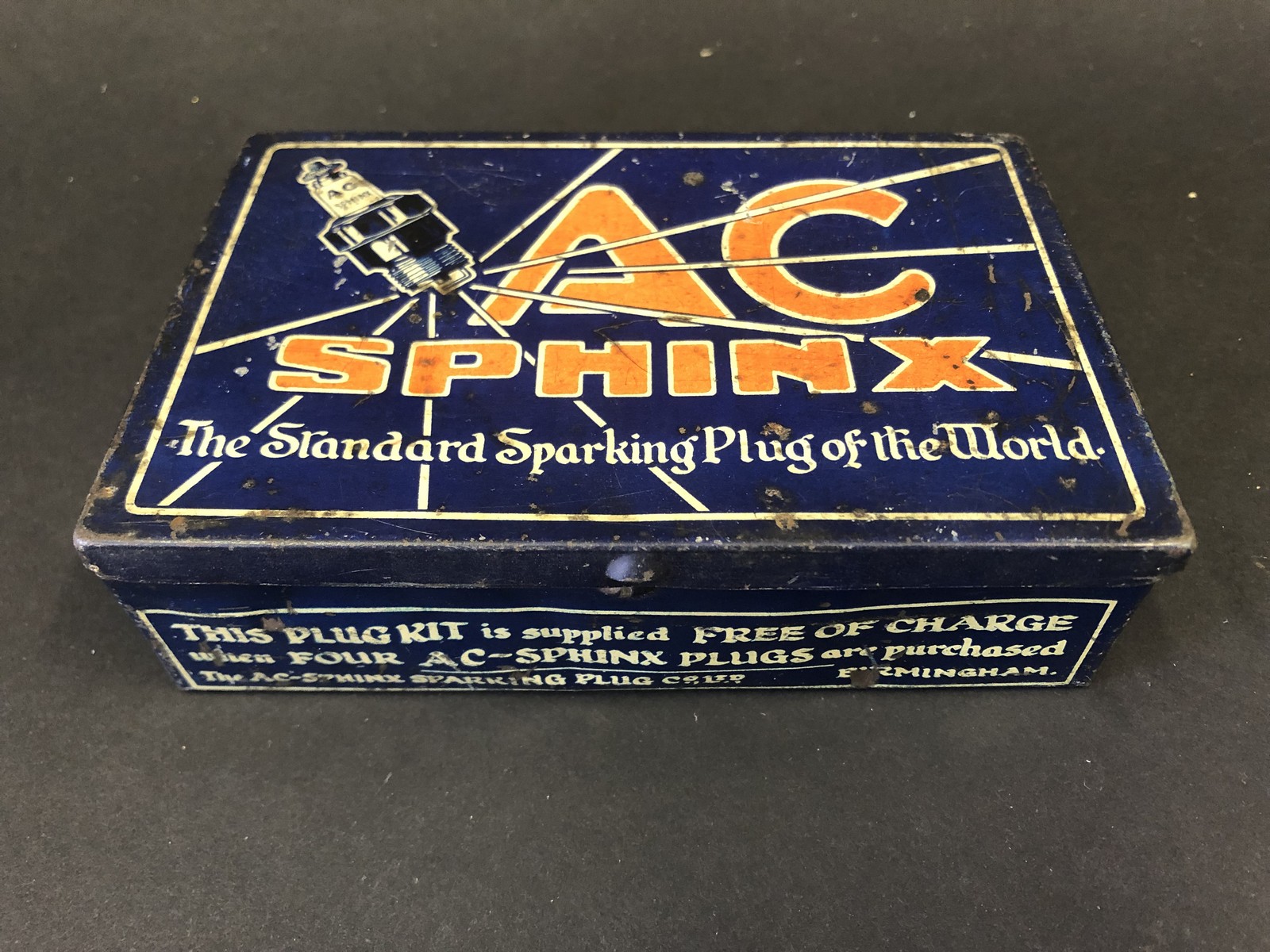 An AC Sphinx Plugs rectangular lidded tin, in good condition.