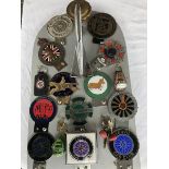 A collection of assorted badges mounted on a display board including the Daimler and Lanchester