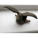 A car accessory mascot in the form of a well detailed bird of prey with outstretched wings,