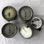 Four Smiths silver faced eight day car clocks and a Smiths black faced 0-40mph speedometer.