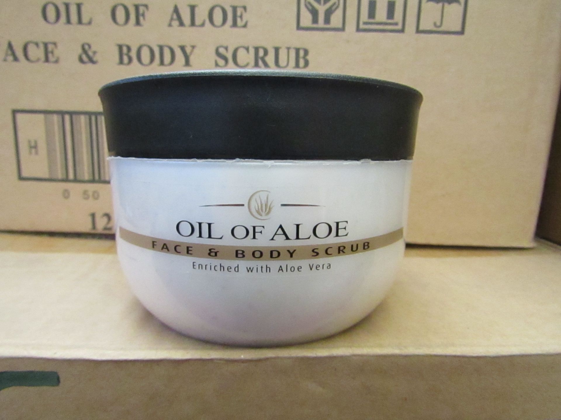 12 x 300ml Oil Of Aloe face and body scrub, unused and boxed.