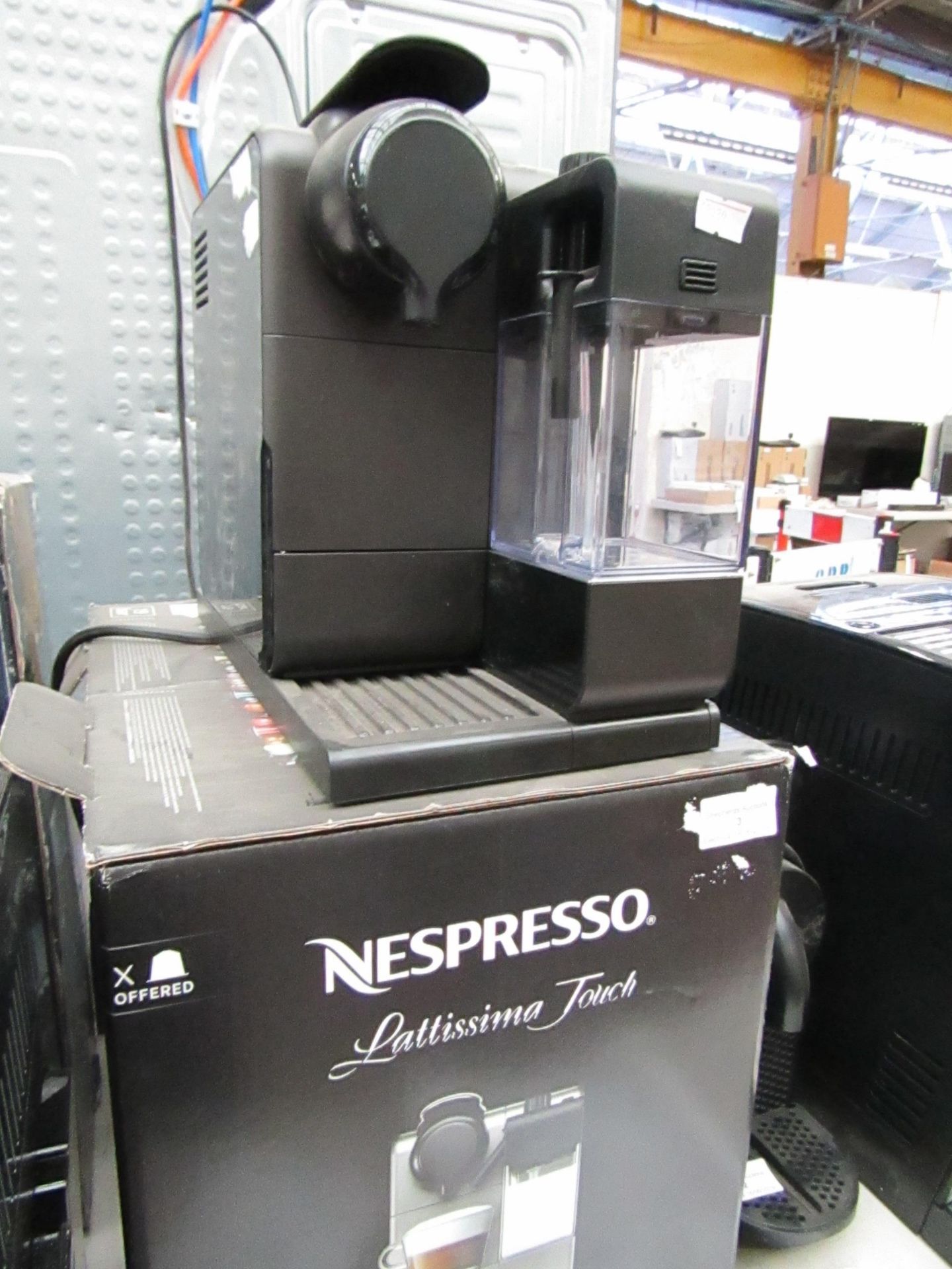 Nespresso Delonghi coffee machine, boxed and powers on.